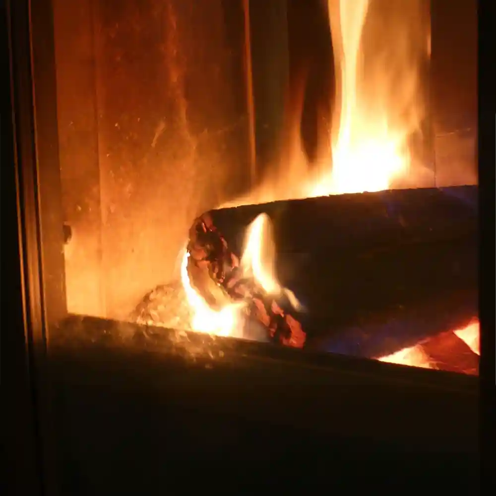 Vuur in kachel met houtblokken