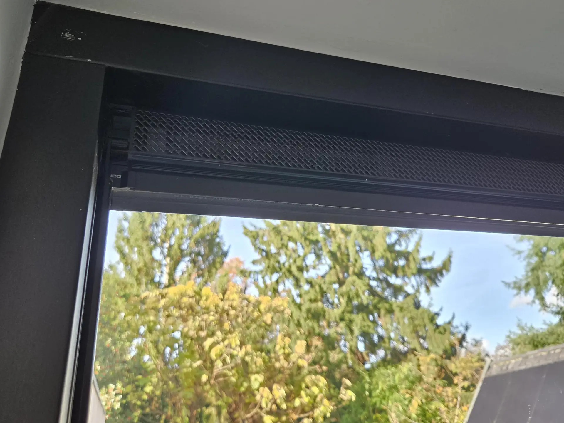 Zwart ventilatierooster in zwart kozijn