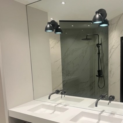 Spiegel boven wastafel met kranen en lampjes